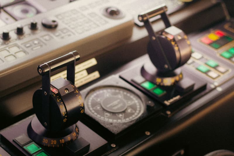 Engine telegraph levers and compass on a ship’s bridge console