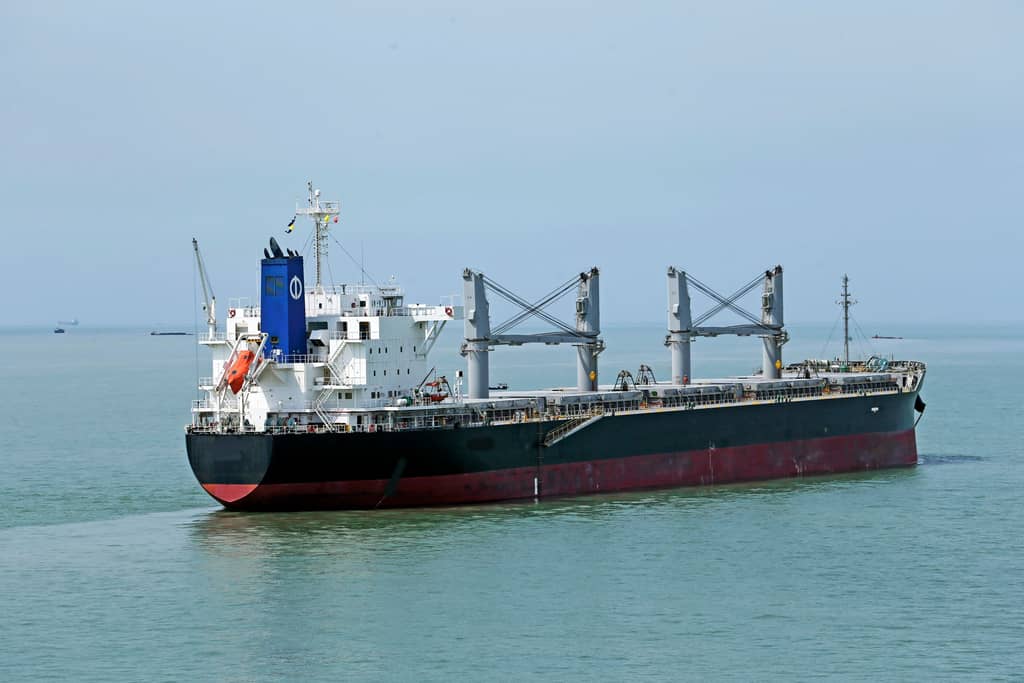 Bulk carrier at anchor in calm turquoise water